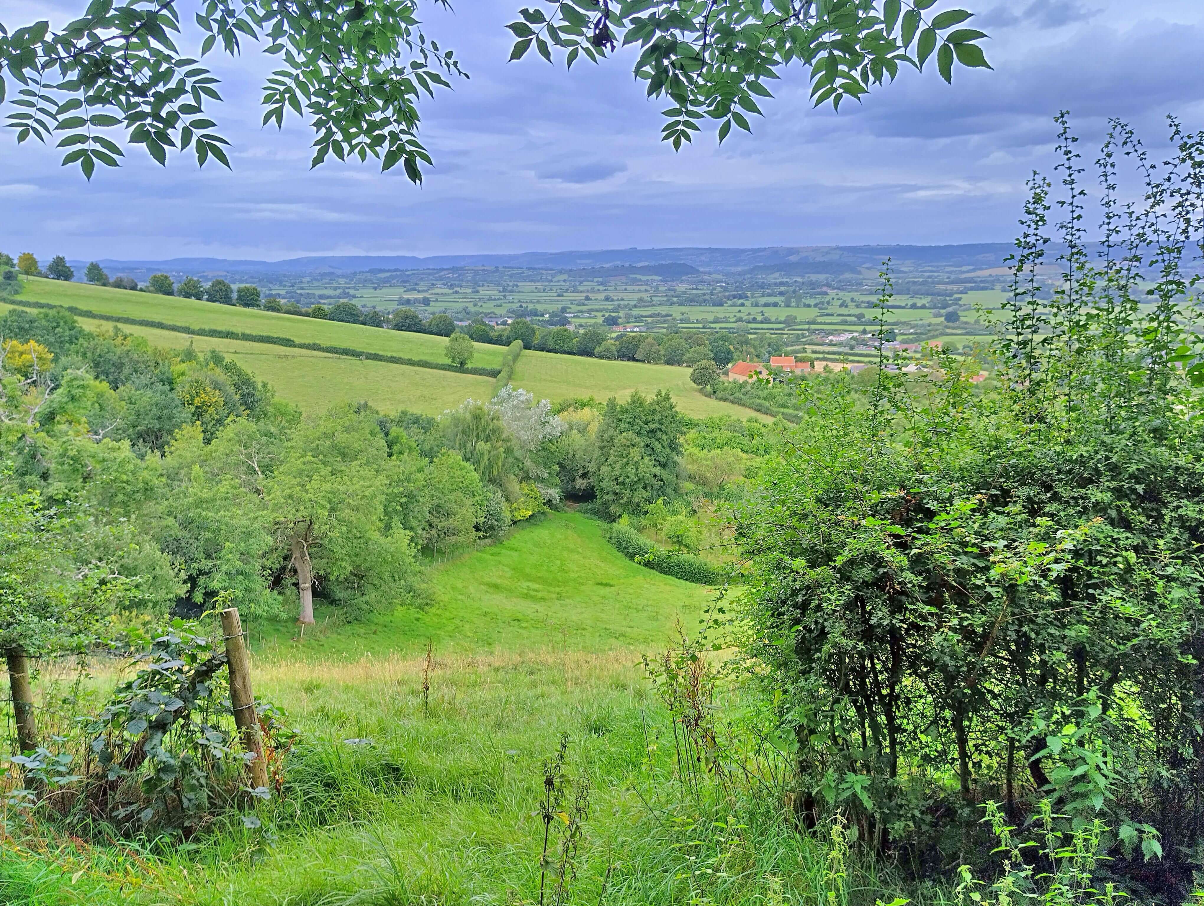 Dark clouds over green hills